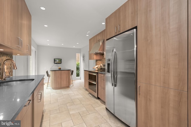 kitchen with stainless steel appliances, a sink, under cabinet range hood, modern cabinets, and decorative backsplash