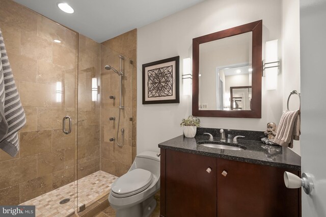 full bath with a stall shower, vanity, toilet, and recessed lighting