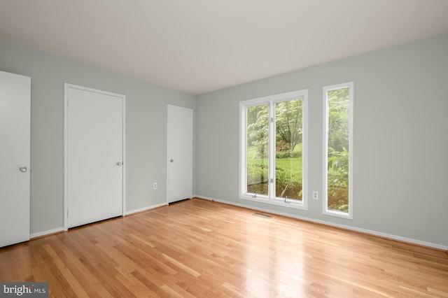 unfurnished bedroom featuring light wood finished floors and baseboards