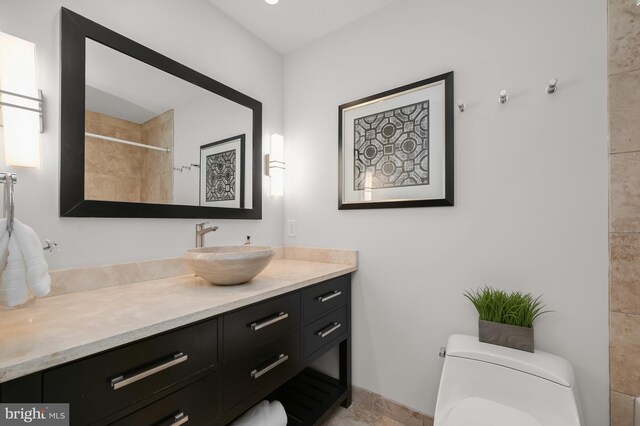 full bath with vanity, toilet, and a tile shower