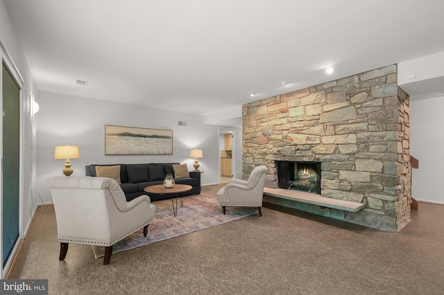 living area with baseboards and a stone fireplace