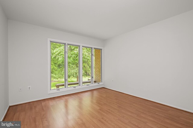 empty room featuring wood finished floors and baseboards