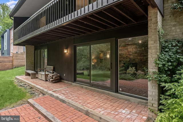 view of patio with a balcony and fence