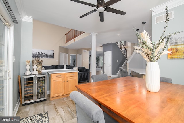 28 Blue Spruce Dr, Bear, DE 19701 - dining space with wine cooler, ceiling fan, stairs, baseboards, and decorative columns