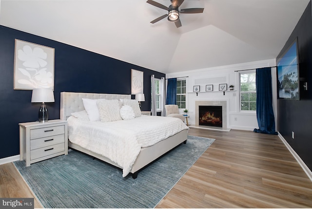 28 Blue Spruce Dr, Bear, DE 19701 - bedroom featuring wood finished floors, lofted ceiling, a warm lit fireplace, ceiling fan, and baseboards