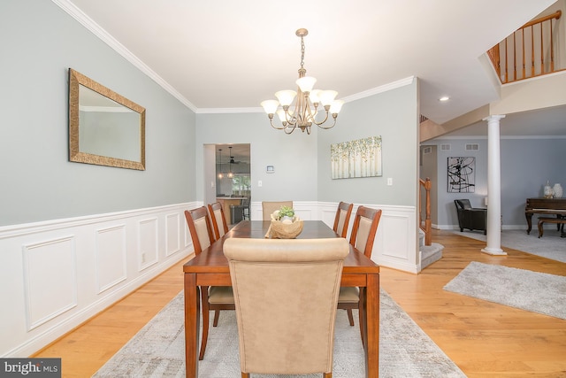 28 Blue Spruce Dr, Bear, DE 19701 - dining area with ornamental molding, a chandelier, light wood finished floors, ornate columns, and wainscoting