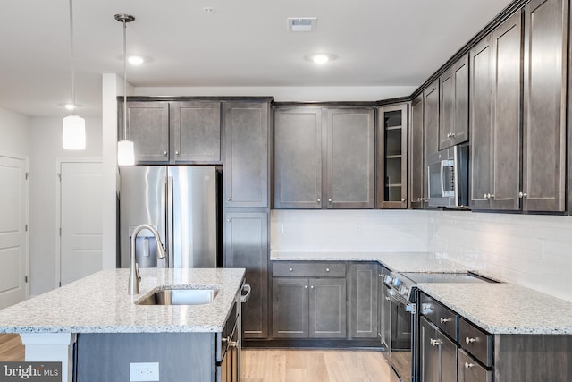 4003 Seaside Alder Rd Unit 0208, Rose, Bowie, MD 20720 - kitchen featuring stainless steel appliances, a sink, light stone countertops, light wood-style floors, and a kitchen island with sink