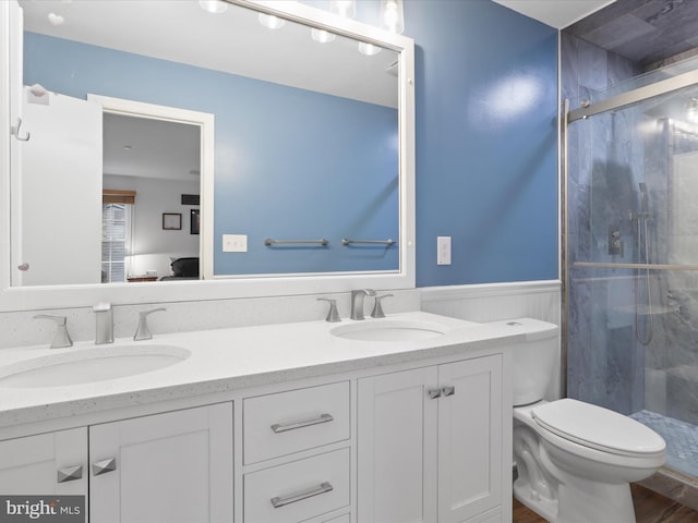 5281 Navaho Dr, Alexandria, VA 22312 - bathroom with a stall shower, double vanity, a wainscoted wall, toilet, and wood finished floors