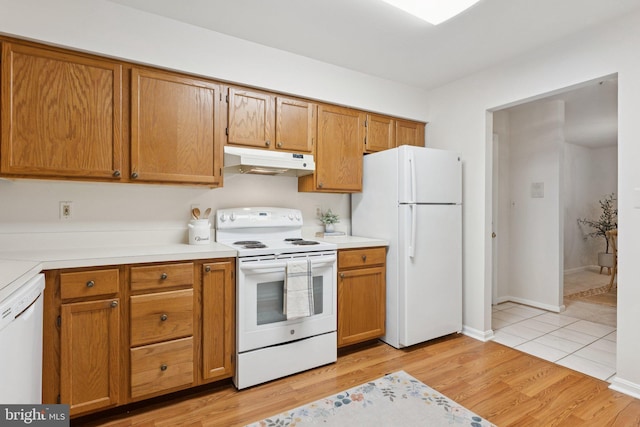 803 Coxswain Way Unit 107, Annapolis, MD 21401 - kitchen with white appliances, under cabinet range hood, light countertops, and light wood-type flooring