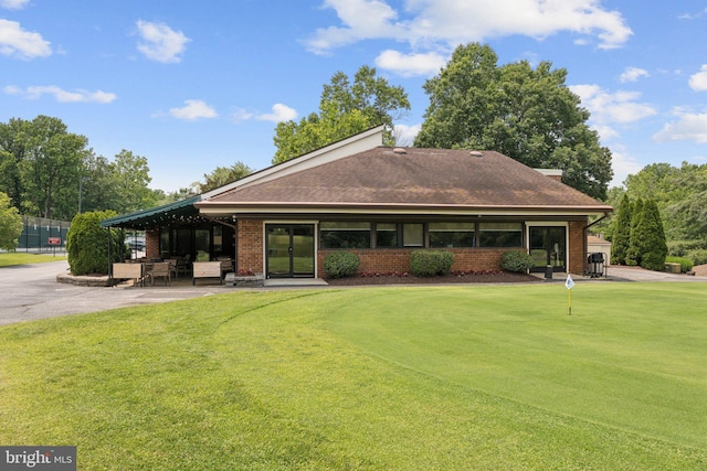 803 Coxswain Way Unit 107, Annapolis, MD 21401 - back of property with an area to practice putting, a shingled roof, a patio, and brick siding