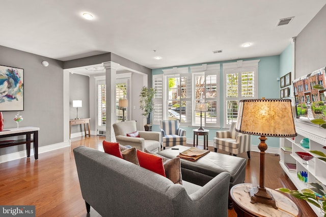 1418 N Rhodes St Unit B105, Arlington, VA 22209 - living area featuring decorative columns, baseboards, wood finished floors, healthy amount of natural light, and recessed lighting