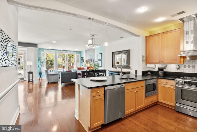 1418 N Rhodes St Unit B105, Arlington, VA 22209 - kitchen featuring appliances with stainless steel finishes, a sink, a peninsula, open floor plan, and dark countertops