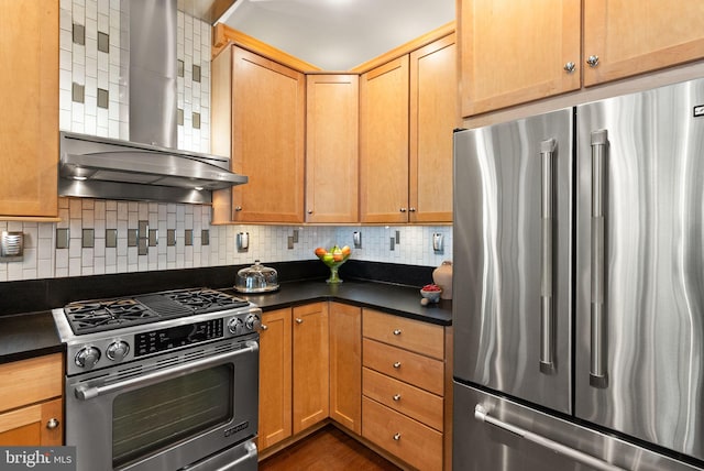 1418 N Rhodes St Unit B105, Arlington, VA 22209 - kitchen with high quality appliances, wall chimney range hood, dark countertops, decorative backsplash, and dark wood-style floors