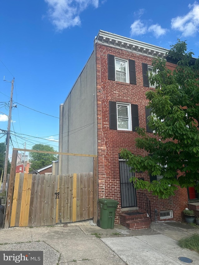 115 Parkin St, Baltimore, MD 21201 - view of front of home featuring brick siding and fence