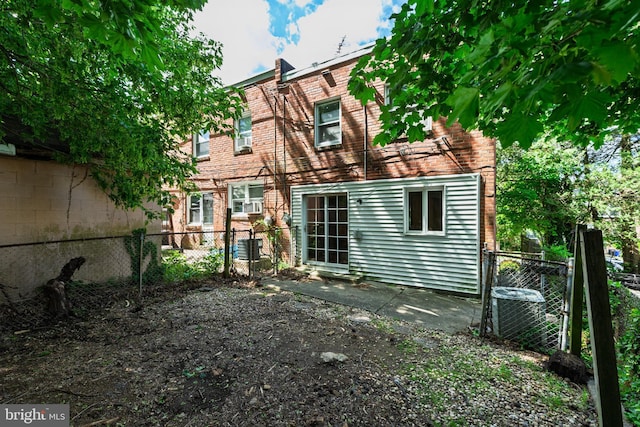 rear view of house featuring fence and cooling unit