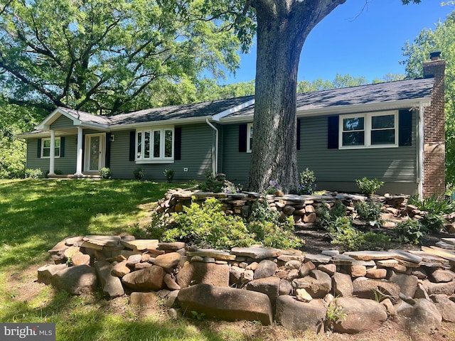 single story home with a chimney, a front yard, and a shingled roof