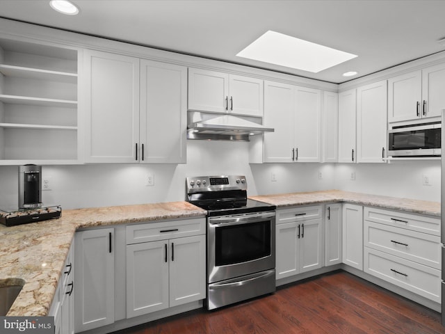 kitchen with stainless steel appliances, under cabinet range hood, a skylight, white cabinets, and dark wood-style floors