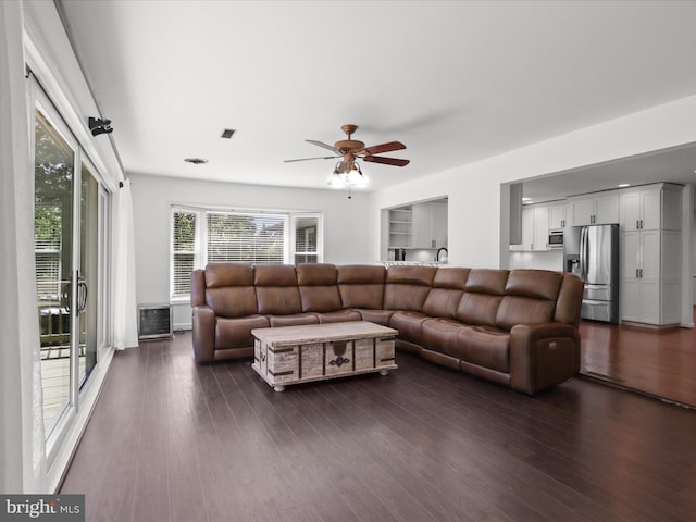 living room featuring ceiling fan and dark wood-style flooring