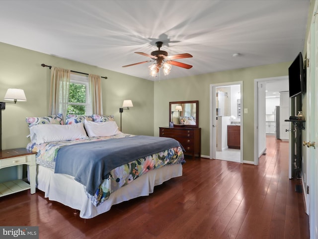 bedroom with wood finished floors, a ceiling fan, baseboards, and ensuite bath
