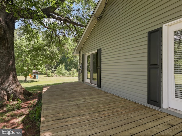 deck featuring a playground and a lawn