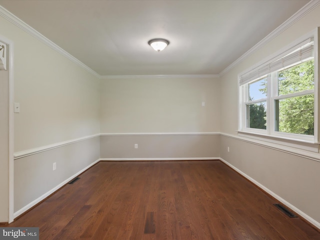 spare room featuring dark wood-style flooring, ornamental molding, and baseboards