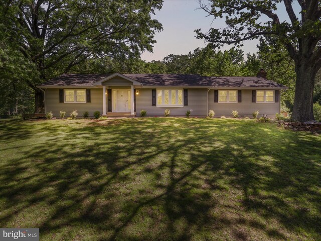 ranch-style house featuring a front yard and a chimney