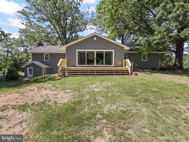 rear view of house with a wooden deck, a chimney, and a lawn