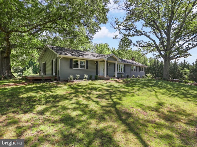 single story home with a chimney, a front lawn, and a wooden deck