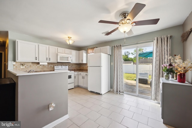 kitchen featuring white appliances, ceiling fan, tasteful backsplash, white cabinetry, and a peninsula