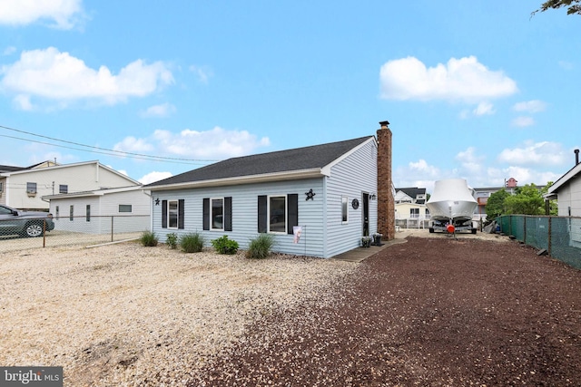 view of front of home with a chimney and a fenced backyard