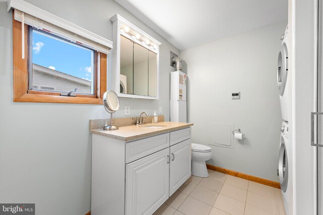 bathroom featuring stacked washing machine and dryer, baseboards, water heater, toilet, and vanity