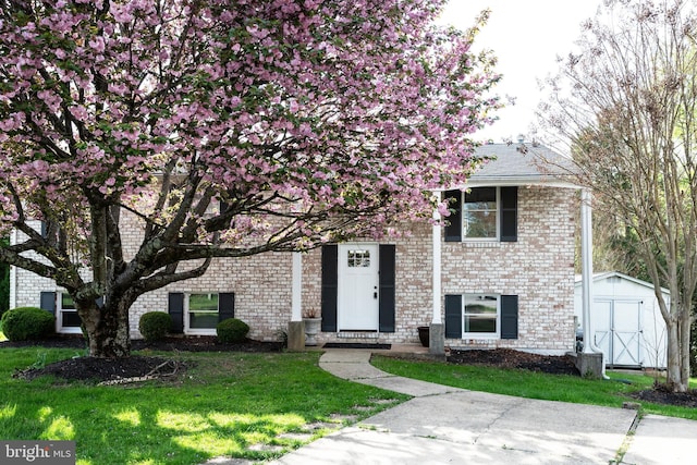 9520 Perry Brook Ct, Nottingham, MD 21236 - view of front of house featuring a storage unit, a front lawn, an outdoor structure, and brick siding