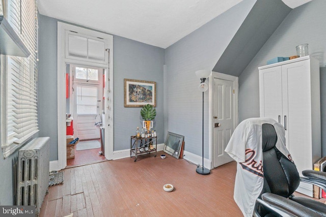 office featuring radiator heating unit, light wood finished floors, and baseboards