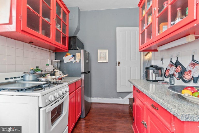 kitchen featuring white gas range oven, decorative backsplash, light countertops, and dark wood-type flooring