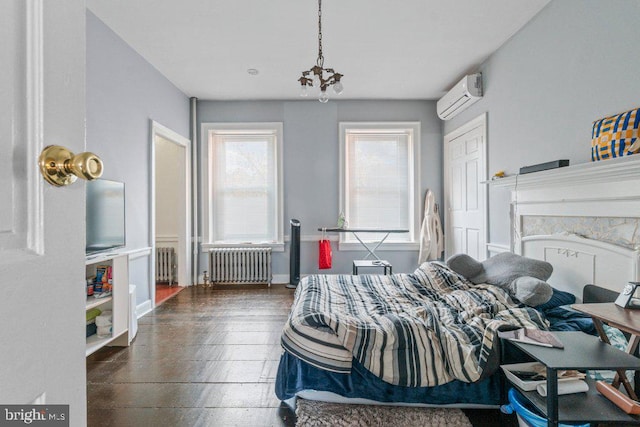 bedroom with radiator, an AC wall unit, a chandelier, and baseboards