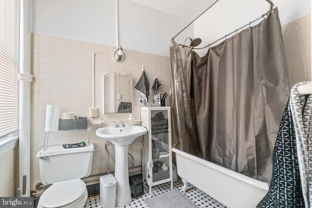 bathroom with tile walls, a bathtub, toilet, and a shower with curtain