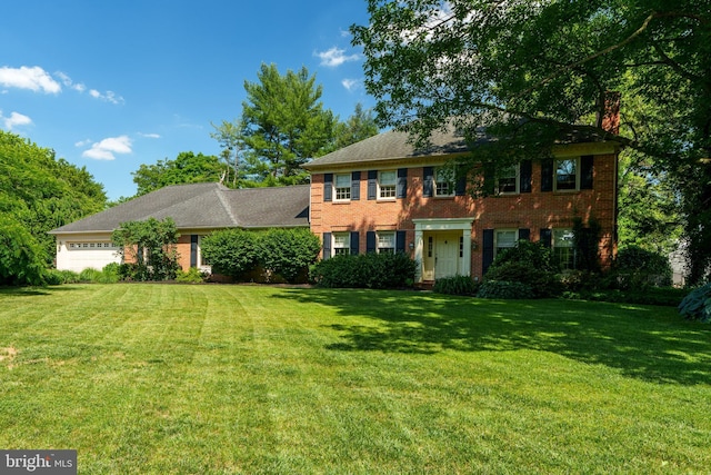 view of front of house with a garage, a front yard, and brick siding