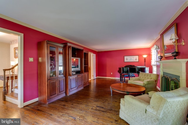 living area with wood finished floors, ornamental molding, baseboards, stairway, and a fireplace