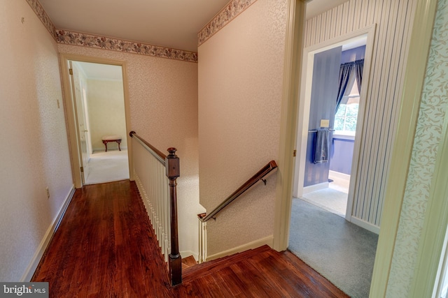 hallway featuring an upstairs landing, wood finished floors, and baseboards
