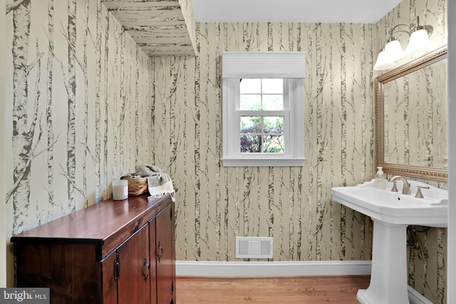 bathroom featuring wallpapered walls and baseboards