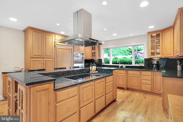 kitchen featuring island range hood, a kitchen island, light wood-style floors, black electric stovetop, and backsplash