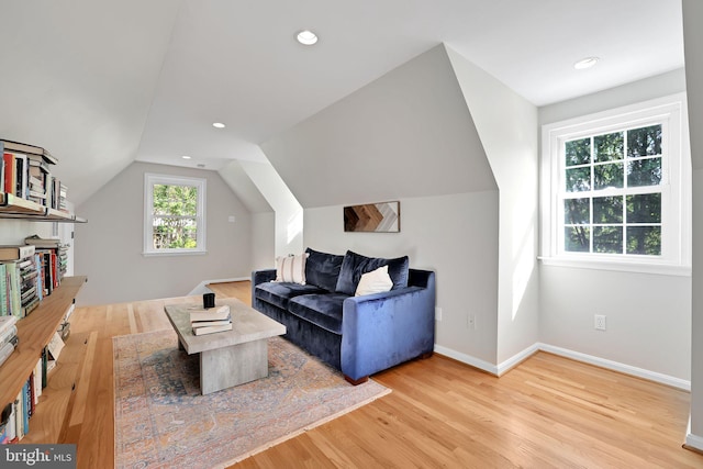 living area featuring wood finished floors, vaulted ceiling, baseboards, and recessed lighting