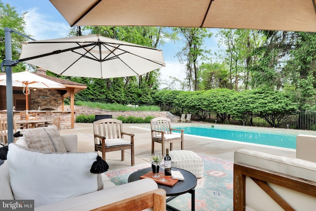 view of swimming pool featuring a patio, an outdoor hangout area, and fence