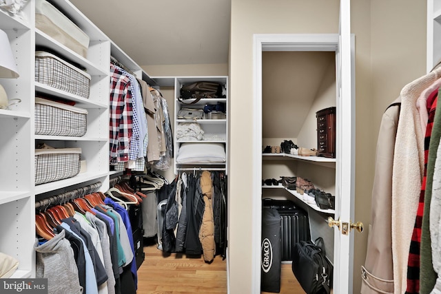 walk in closet with wood finished floors