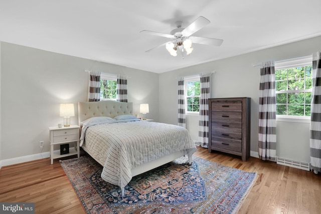 bedroom with wood finished floors, baseboards, and a ceiling fan