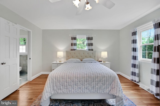 bedroom with light wood-style floors, baseboards, connected bathroom, and ceiling fan