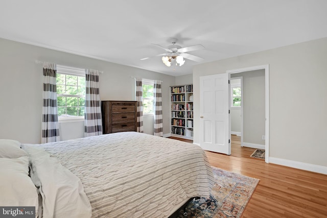 bedroom featuring baseboards, wood finished floors, and ceiling fan