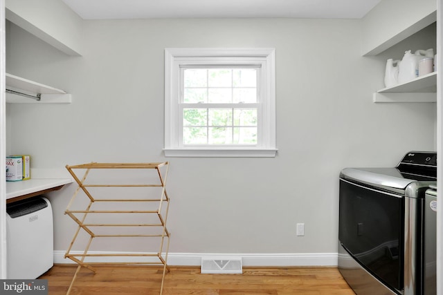 laundry area featuring independent washer and dryer, wood finished floors, and baseboards