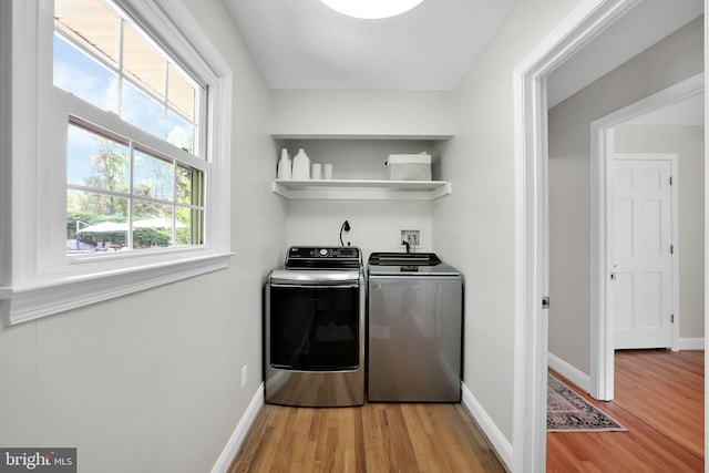 washroom with separate washer and dryer, light wood-style floors, and baseboards