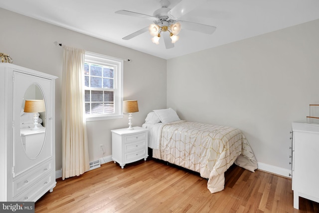 bedroom with light wood-style floors, baseboards, and a ceiling fan